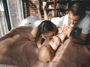 forældre og baby på seng